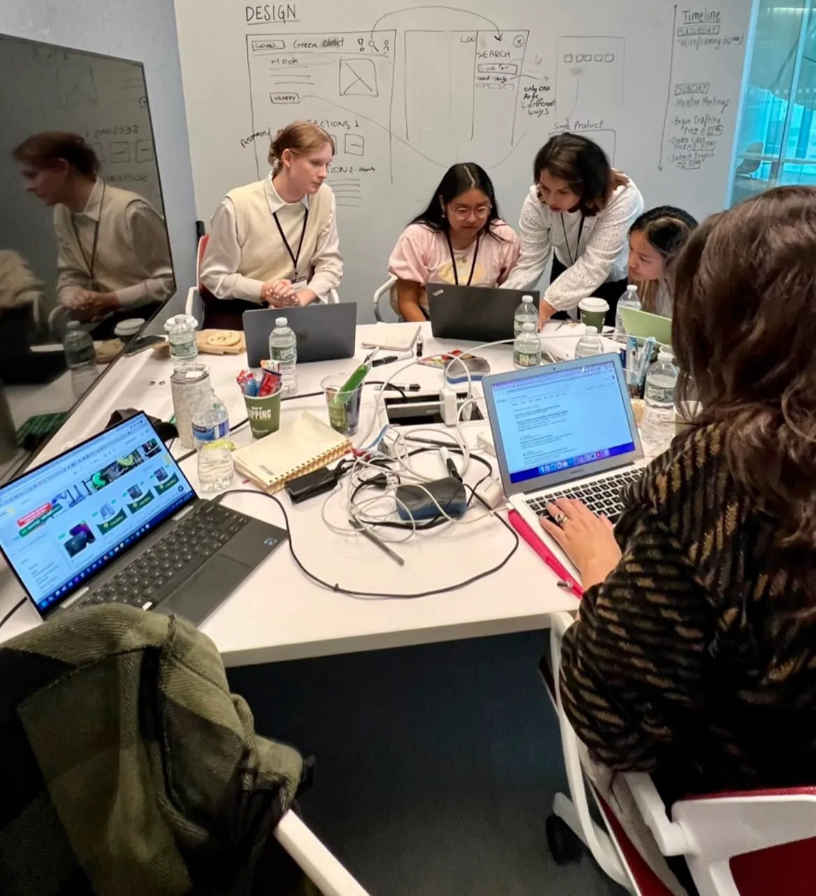 Farnaz working with teammates at a hackathon table